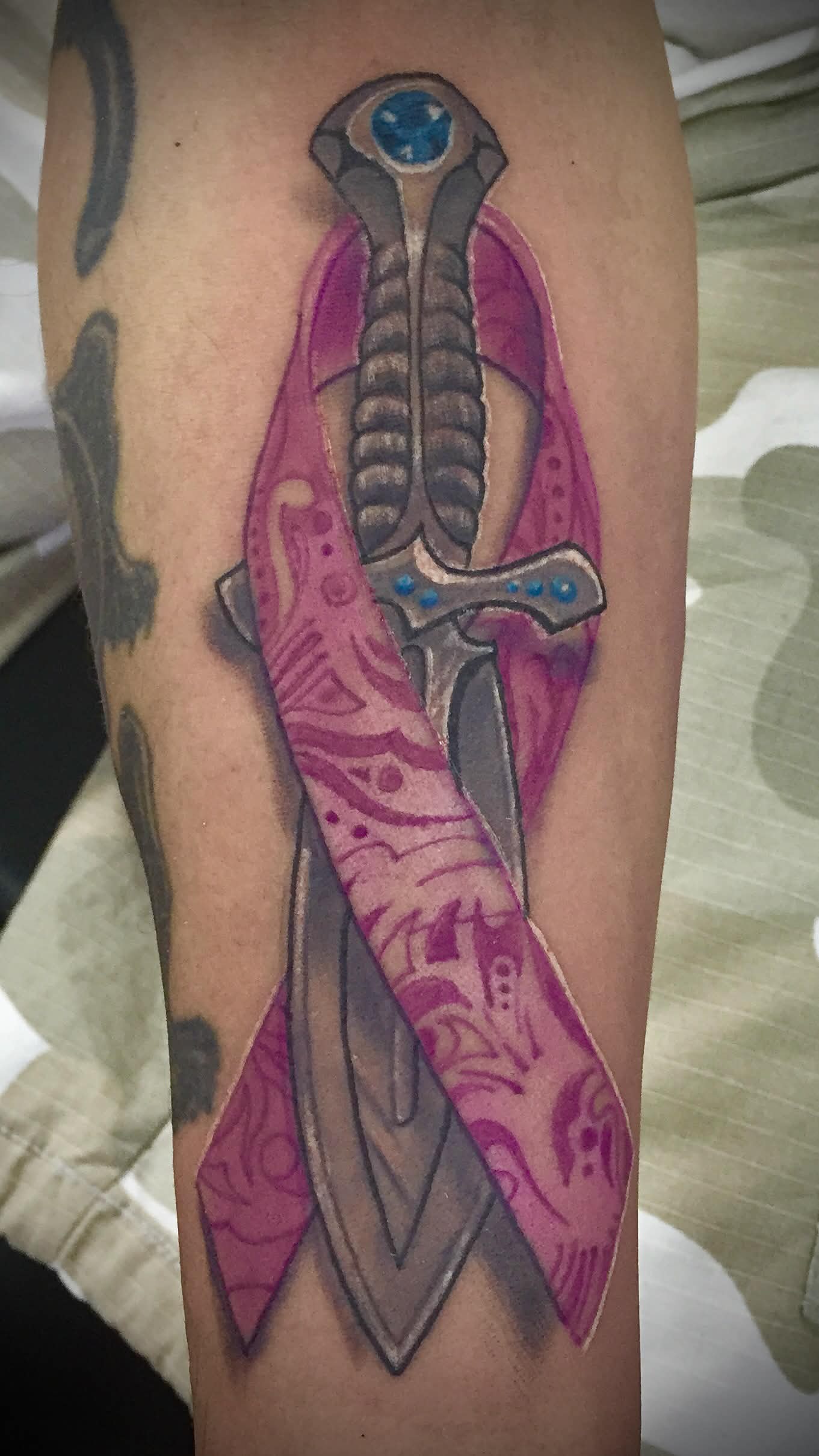 Cancer ribbon dagger tattoo — meaningful same-day work by Spade
